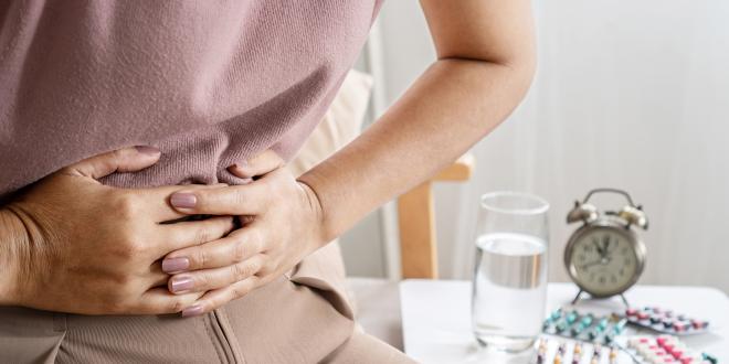 a woman clutching her abdomen in pain