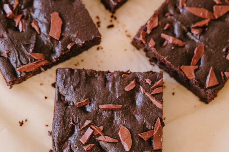 freshly baked brownies cut into squares on parchment paper.